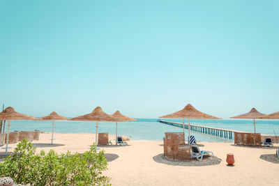 Beach umbrellas and chaise lounges under beautiful blue sky 