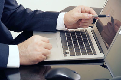 Midsection of man using mobile phone