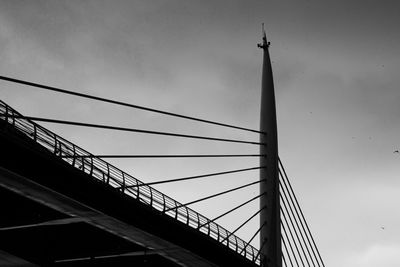 Low angle view of suspension bridge against sky