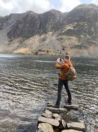 Full length of man standing on rock in water