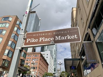 Low angle view of information sign against buildings