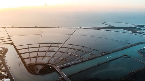 High angle view of glass on table by sea against sky