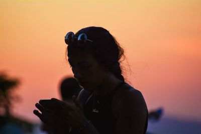 Portrait of silhouette man using smart phone against sky during sunset