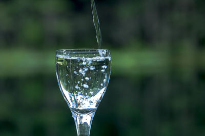 Water pouring in wineglass