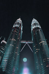 Low angle view of illuminated buildings against sky at night