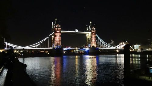 Suspension bridge over river at night