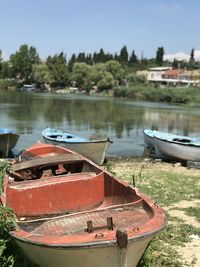 Boat moored on lake against sky