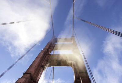 Low angle view of bridge against cloudy sky