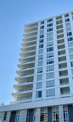 Low angle view of modern building against clear blue sky