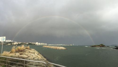 Scenic view of rainbow over sea against sky