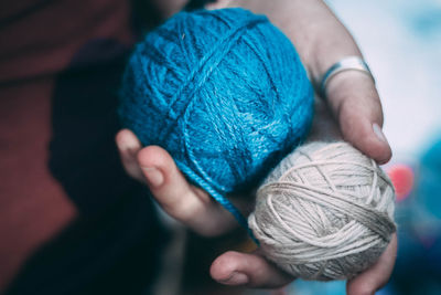 Cropped hand of person holding woolen balls