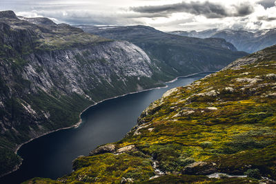 Aerial view of lake by mountain against sky