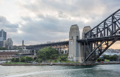 Bridge over river in city against sky