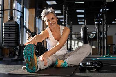 Side view of young woman exercising in gym