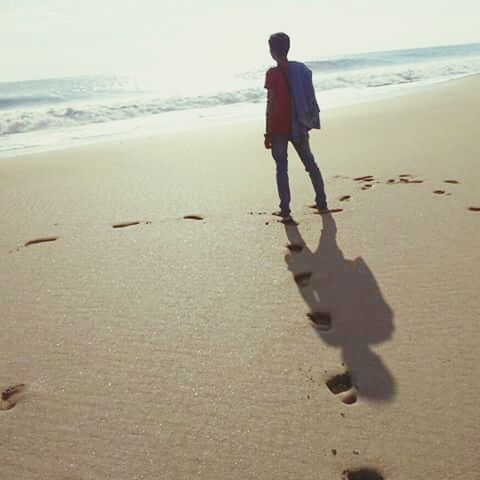 beach, sea, sand, horizon over water, shore, water, lifestyles, leisure activity, full length, vacations, walking, rear view, standing, wave, tranquility, nature, person, sunlight