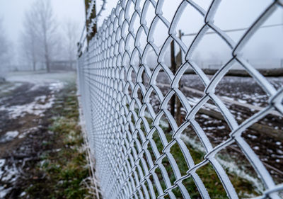 Close-up of barbed wire fence during winter