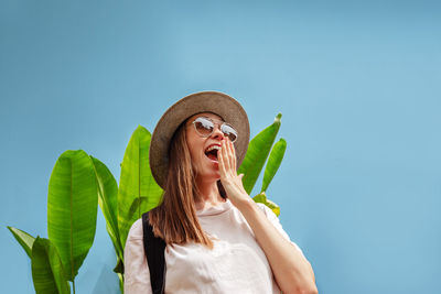 Portrait of young woman against clear sky