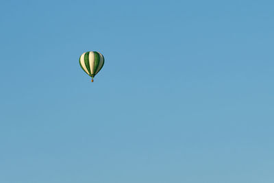 A green balloon in a clear blue sky.