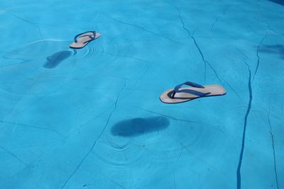 High angle view of slippers floating on swimming pool