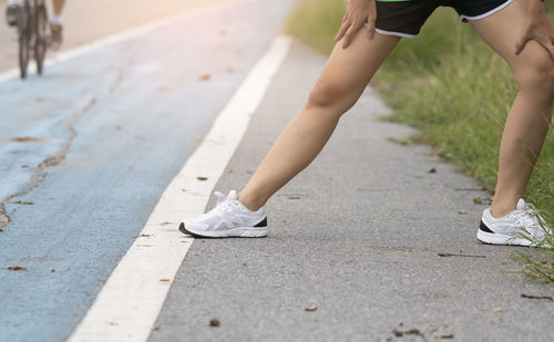 Low section of woman running on street