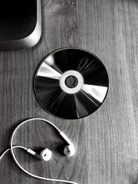 High angle view of compact disk and headphones on table