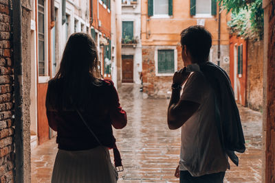 Rear view of people walking on street in city