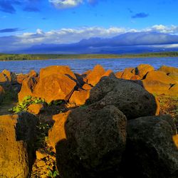 Rock formation on beach against sky