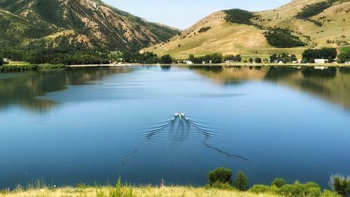 Scenic view of lake by trees against sky