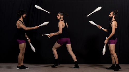 Men juggling while standing at stage