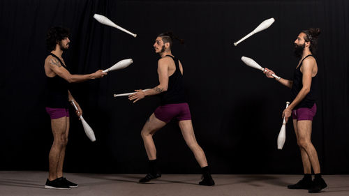 Friends standing against black background