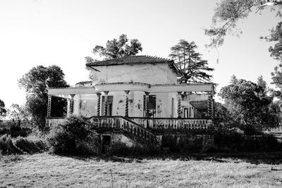 Abandoned house on field against clear sky