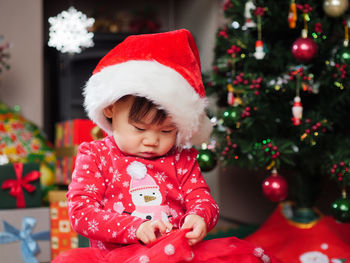 Close-up of baby girl with christmas present at home