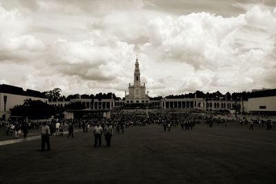 Crowd at sanctuary of fatima against cloudy sky