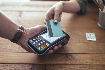 Female customer making contactless payment through credit card in restaurant