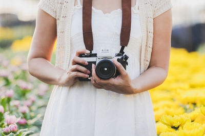 Midsection of woman photographing at camera