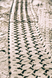 Full frame shot of tire tracks on sand