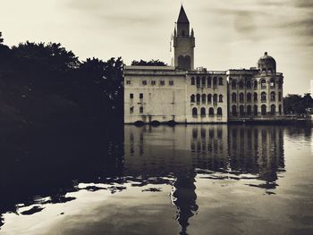 Reflection of building in lake against sky