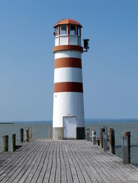 Lighthouse on beach against clear sky