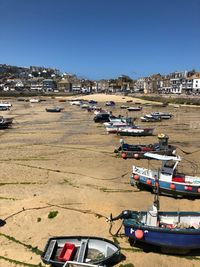 Boats moored at beach against clear sky