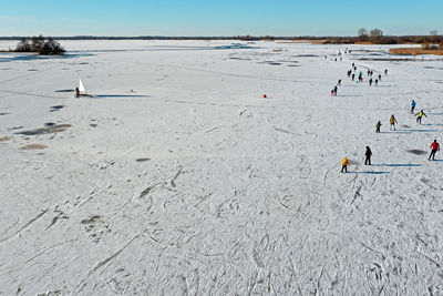 Aerial from ice sailing and skating on bergumer lake in winter in friesland the netherlands