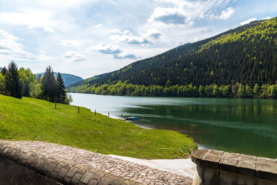 Scenic view of lake by trees against sky