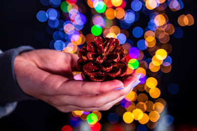 Close-up of person holding multi colored lights