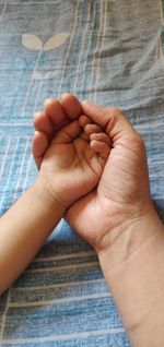 Midsection of mother holding baby hand