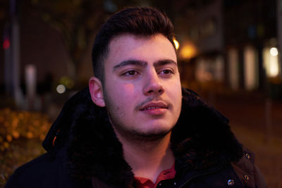 Portrait of young man looking away outdoors