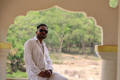 Portrait of young man wearing sunglasses while standing in city