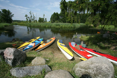 Boats moored on lake against trees