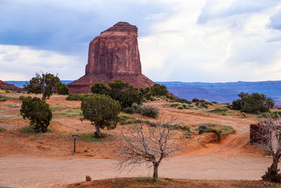 Built structure on landscape against cloudy sky