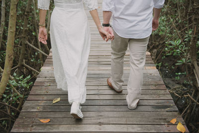 Low section of couple standing on footpath
