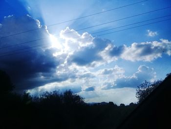 Low angle view of silhouette trees against sky