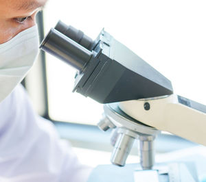 Close-up of scientist looking through microscope